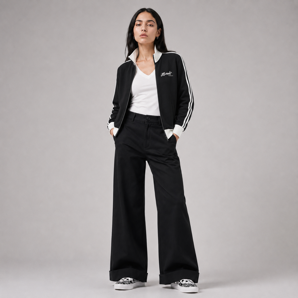 Femme portant la veste de survêtement Witness de Bandit noire avec fermeture zippée et bandes blanches, collection Therapy For Earth.